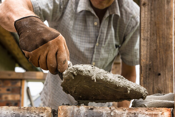 A worker is laying a brick wall.