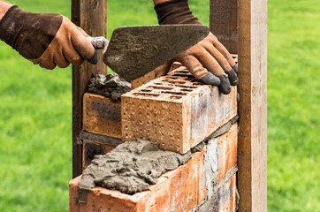 A worker is laying a brick wall.