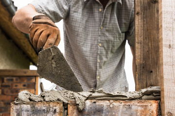 A worker is laying a brick wall.
