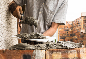 A worker is laying a brick wall.