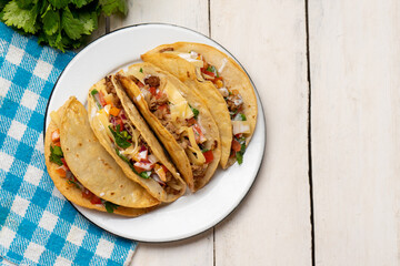 Mexican hard-shell tacos with meat and fresh sauce on white background