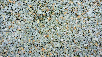 Stone background from crumbs of natural stone jasper, granite, gabbro, pebbles for landscape design, garden paths, rockeries, rock gardens. Small stones texture.
