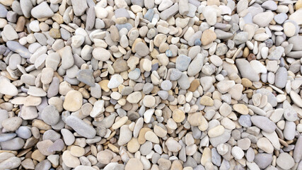 Sea pebbles background. The texture of small black sea pebbles. Beautiful design template with mosaic sea pebbles background. Sea pebbles in landscaping, garden paths, rockeries.