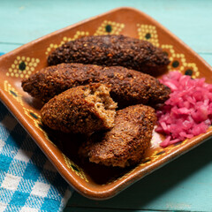 Mexican kibi with meat and onion on turquoise background