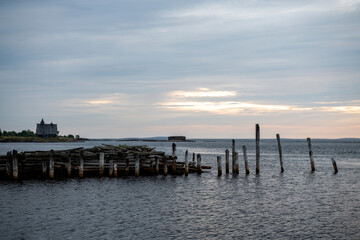 Fototapeta premium beautiful landscape with old wooden port, stones and sea at sunrise