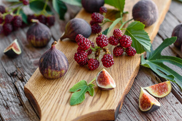 Fresh juicy figs and blackberries on a dark background