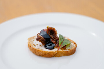 Bruschetta with dried vegetables on white plate. Decorated catering banquet menu with different food snacks and appetizers with sandwich.