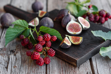 Obraz na płótnie Canvas Fresh juicy figs and blackberries on a dark background