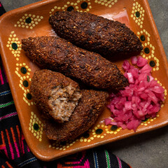 Mexican kibi with meat and onion on rustic background