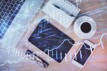 Multi exposure of forex graph hologram over desktop with phone. Top view. Mobile trade platform concept.