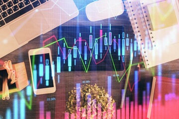 Double exposure of forex chart hologram over desktop with phone. Top view. Mobile trade platform...