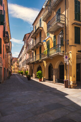 Fototapeta premium Typical colorful building on narrow cobblestone street in Mondovi, Cuneo, Piedmont