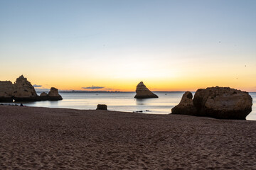Naklejka na ściany i meble Sunrise on the beach. Early morning, calm ocean. Lagos, Algarve Coast, Portugal