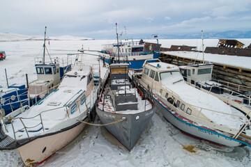 Barcos nevados varados en el hielo en el lago baikal, desde punto de vista aéreo.