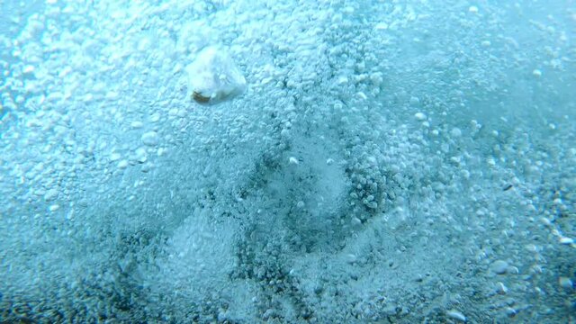 Bubbles in river from above while falling underwater as if drowning in strong river current.