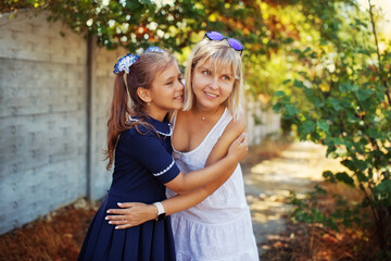 Fototapeta premium schoolgirl hugs mom after school