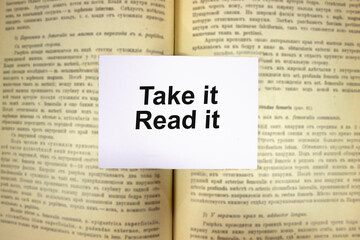 Obraz premium Take it, read it written in white note on open book