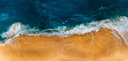 Beautiful sandy beach, top view. Panoramic view of the sandy beach. The sea wave rolls on the...