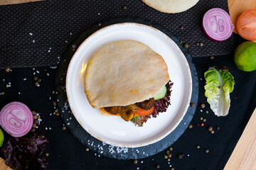 Pita with hummus in the man's hands. Close up view of street food pita