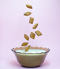 levitate breakfast dried chocolate pads on pink background with milk. Healthy tasty breakfast chocolate square pads.