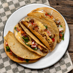Mexican hard-shell tacos with meat and fresh sauce on wooden background