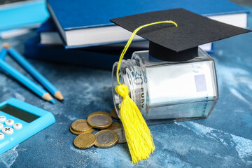 Jar with money and graduation hat on table. Tuition fees concept