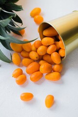 exotic kumquat fruit spilled out of a bucket on a white background