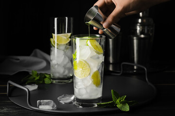 Woman making fresh mojito at table