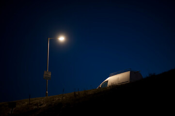 white van parked under a streetlight at night