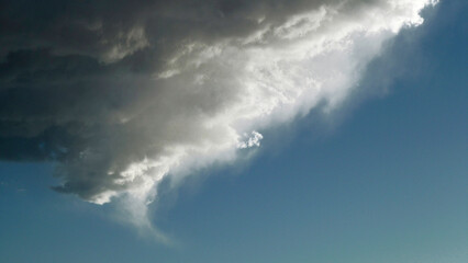 wispy edge of clouds backlit by the afternoon sun above the clouds