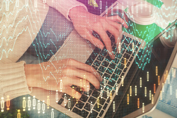 Double exposure of woman hands typing on computer and forex chart hologram drawing. Stock market invest concept.