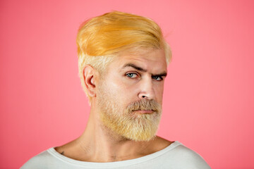 Portrait of blonde serious man has beard and mustache, looks seriously, isolated. Barber with long beard and moustache in barbershop. Bearded man.