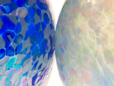 macro closeup of two handmade glass globes ornaments touching, reminiscent of planets colliding