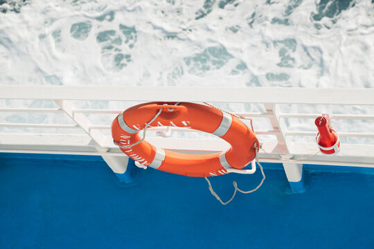 Orange lifesaver attached to railing on a ship shot from above