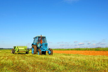 Obraz premium Tractor in a farmer's field. Agroindustrial production. Harvest season