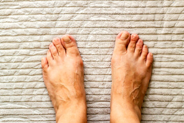 A pair of bare feet on the bath mat, top shot