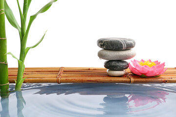 Stack of spa stones, pond and bamboo on white background