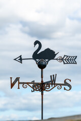 An iron cast and rusty swan wind rose.