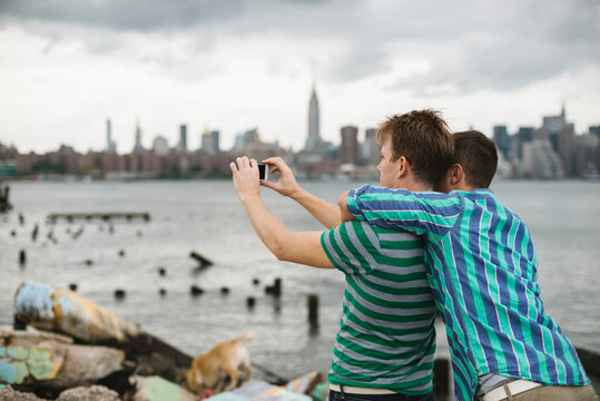 Gay couple taking a selfie against Manhattan skyline