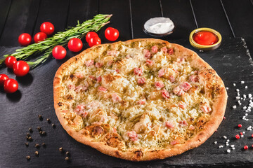 Traditional Italian focaccia among tomato and spices on a dark background, studio light. Traditional food concept