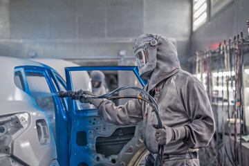 employee body painting workshop carries out painting of the internal elements of the car.