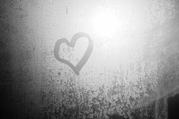 Blurred love heart on window, closeup on fogged drops sun shining outdoors background.