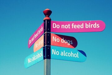 Lots of rules on a sign forbidding people to have dogs or feed birds
