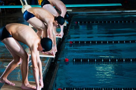 Male swimmers on starting blocks about to race