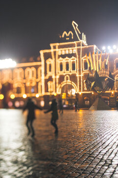 Pair walking near Moscow Upper Trading Rows (""GUM"") at night