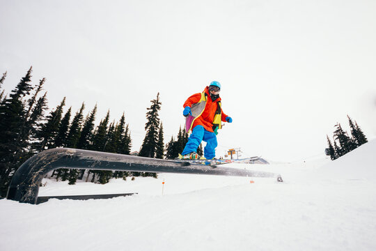 Skier sliding on a rail in a snowpark of ski resort