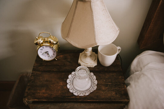 Vintage cozy cottage bedside table with alarm clock