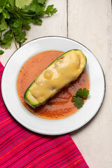 Stuffed zucchini with tuna and melted cheese on white background