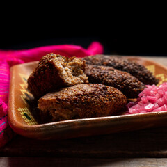 Mexican kibi with meat and onion on wooden background