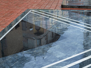 building reflected on the pavement wet from the rain